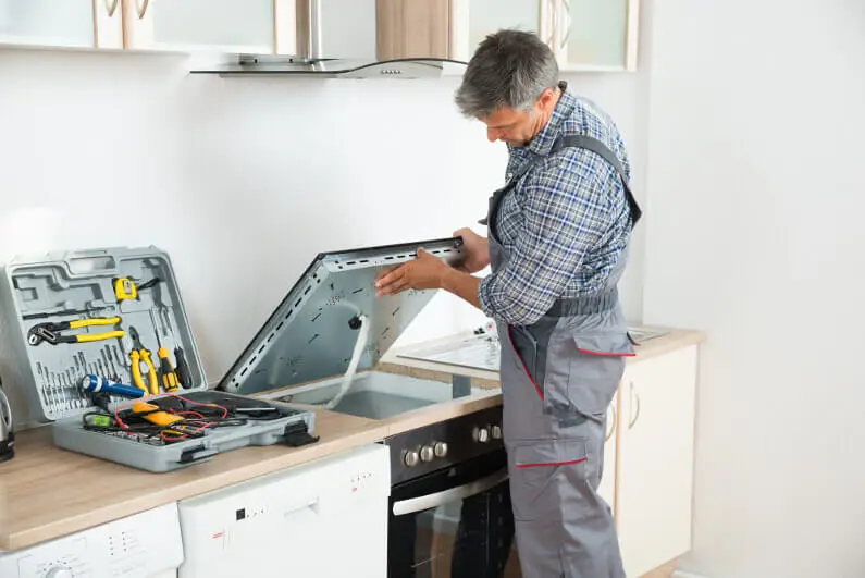 Stove repair specialist at work.